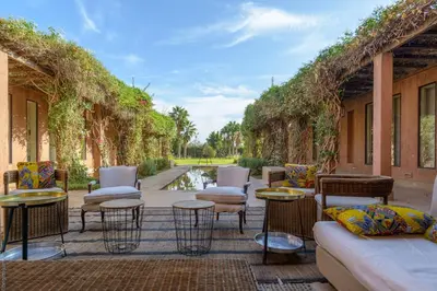 a patio with chairs and tables and vines at Villa Fatima, Route de Fès in Oulad Akkou