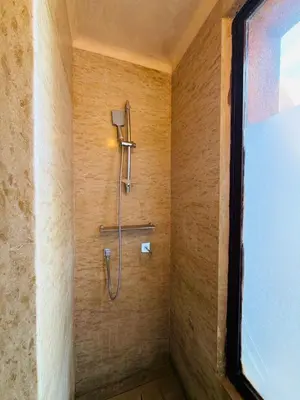 a bathroom with a shower in a wall at Villa Fatima, Route de Fès in Oulad Akkou