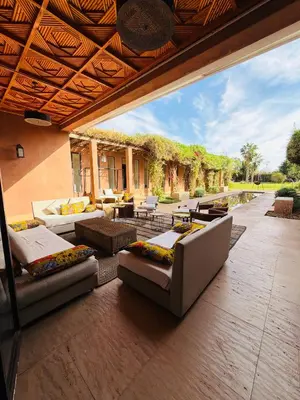 an outdoor patio with couches and tables and chairs at Villa Fatima, Route de Fès in Oulad Akkou