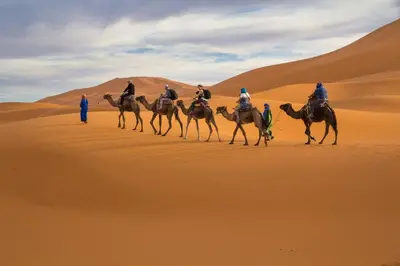a group of people riding horses in the desert at Merzouga Boho Camp in Merzouga