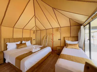 a bedroom with two beds in a tent at Merzouga Sahara Nights Tents in Merzouga