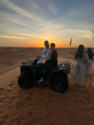 a group of people sitting on a jeep in the desert at Merzouga Sahara Nights Tents in Merzouga