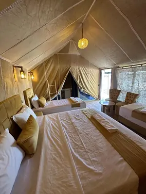 a bedroom with two beds in a tent at Merzouga Sahara Nights Tents in Merzouga