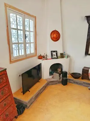 a living room with a tv and a fireplace at Authentic Berber Home Retreat Ourika Valley in Aghmat