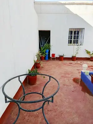 a metal bench in a courtyard with potted plants at Authentic Berber Home Retreat Ourika Valley in Aghmat