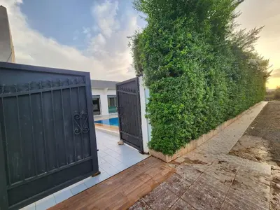 a fence with two gates next to a hedge at Villa Luxe Fès avec Piscine & Spa, proche aéroport, Private Hammam in Fès