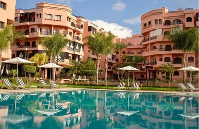 a swimming pool in front of a building at Premium village marrakech in Ville Nouvelle