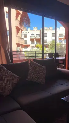 a couch in a living room with a large window at Premium village marrakech in Ville Nouvelle
