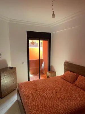 a bedroom with a bed and a dresser and a window at Premium village marrakech in Ville Nouvelle