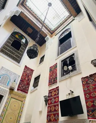 a room with a wall with windows and a tv at Riad Panoramik in Fès