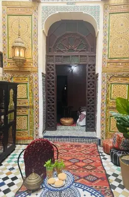 a room with a table and chairs in a building at Riad Panoramik in Fès