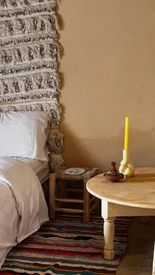 a bedroom with a bed and a table with a candle at Merzouga Nomad House in Merzouga