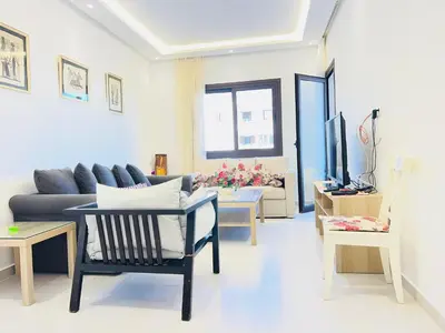 a living room with a couch and a table at Colina Smir par Immo Marina Vacances de Rêve C1-10 in Oulad Akkou