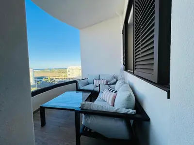 a living room with a couch and a glass table at Colina Smir par Immo Marina Vacances de Rêve C1-10 in Oulad Akkou