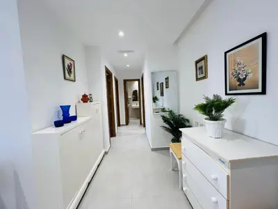 a hallway with white cabinets and plants on the walls at Colina Smir par Immo Marina Vacances de Rêve B1-10 in Oulad Akkou