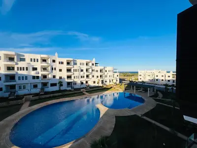 a large swimming pool in front of some buildings at Colina Smir par Immo Marina Vacances de Rêve B1-10 in Oulad Akkou