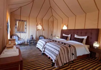 a bedroom with a large bed in a tent at Sahara Relax Camps in Zagora