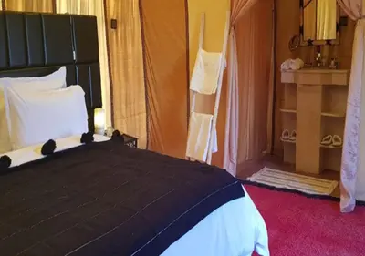 a bedroom with a black and white bed in a room at Sahara Relax Camps in Zagora