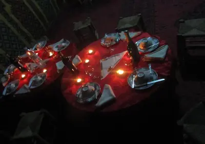 a table with a red table cloth with lights on it at Sahara Relax Camps in Zagora