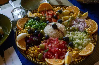 a plate of food with fruit and vegetables on a table at Sahara Relax Camps in Zagora