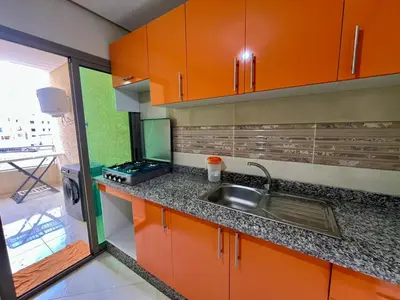 a kitchen with orange cabinets and a sink at Appart Hotel Noor Fes - Family & Traveler Apartments in Fès