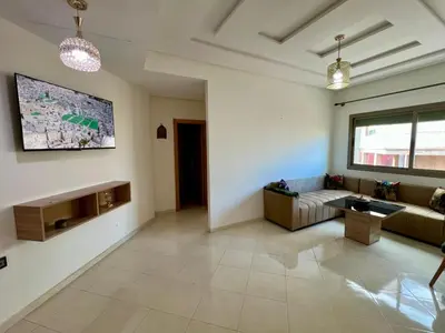 a living room with a couch and a tv on the wall at Appart Hotel Noor Fes - Family & Traveler Apartments in Fès