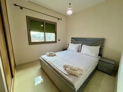 a bedroom with a large bed with two towels on it at Appart Hotel Noor Fes - Family & Traveler Apartments in Fès