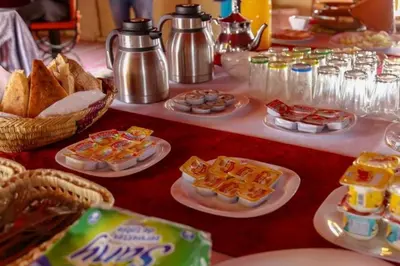a table filled with different types of food on plates at Sahara desierto Camp in Merzouga