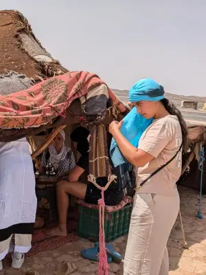 a woman is standing next to an elephant at Sahara desierto Camp in Merzouga