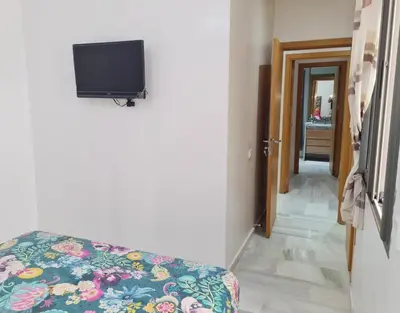 a room with a couch and a tv on the wall at Confort in Fès