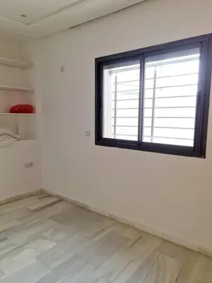 a white room with a window and a wooden floor at Confort in Fès