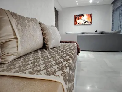 a living room with a couch and a television at Confort in Fès