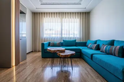 a living room with a blue couch and a table at Aquarium et Luxe Central in Oulad Akkou