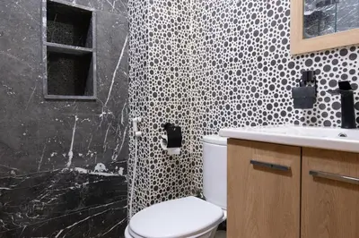 a black and white bathroom with a toilet and a sink at Aquarium et Luxe Central in Oulad Akkou