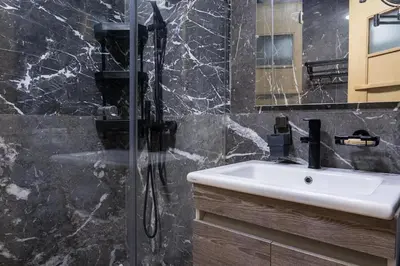 a bathroom with a sink and a glass shower at Aquarium et Luxe Central in Oulad Akkou