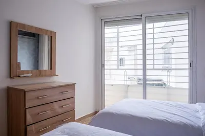 a bedroom with a bed and a dresser and a window at Aquarium et Luxe Central in Oulad Akkou