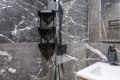 a shower with a glass door next to a sink at Aquarium et Luxe Central in Oulad Akkou