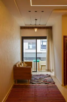 a living room with a couch and a large window at appartement nassime fes 4 chambre in Fès