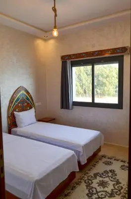 two beds in a room with a window at appartement nassime fes 4 chambre in Fès