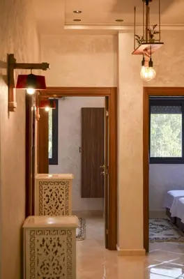 a room with a door and a room with a table at appartement nassime fes 4 chambre in Fès