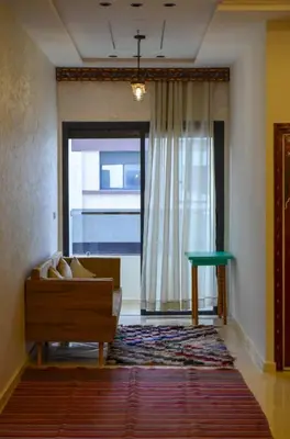 a living room with a couch and a window at appartement nassime fes 4 chambre in Fès