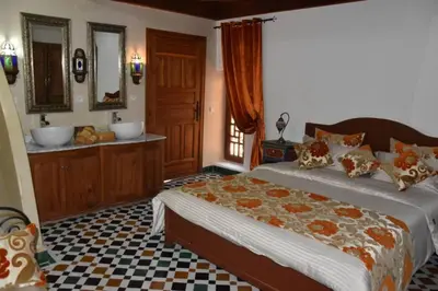 a bedroom with a large bed and a bathroom at Chambre topaze - Riad lotus bleu in Fès