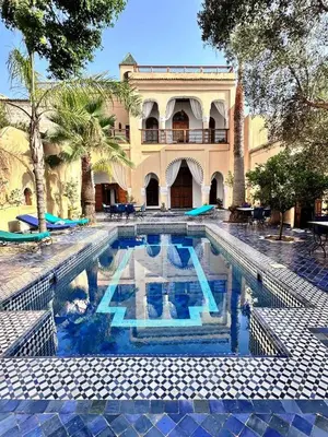 a swimming pool in front of a building at Chambre topaze - Riad lotus bleu in Fès