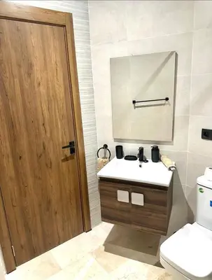 a bathroom with a sink and a mirror and a toilet at Garden View- Gueliz-Majorelle appartement 2 chambres- Wifi et piscines in Oulad Akkou