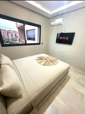 a bed in a room with a sign on the wall at Garden View- Gueliz-Majorelle appartement 2 chambres- Wifi et piscines in Oulad Akkou