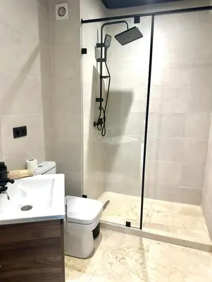 a bathroom with a shower with a toilet and a sink at Garden View- Gueliz-Majorelle appartement 2 chambres- Wifi et piscines in Oulad Akkou