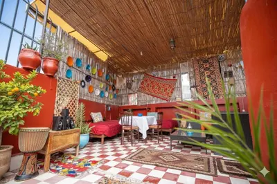 a dining room with a table and red walls at Fes Medina Vibes Hostel in Fès