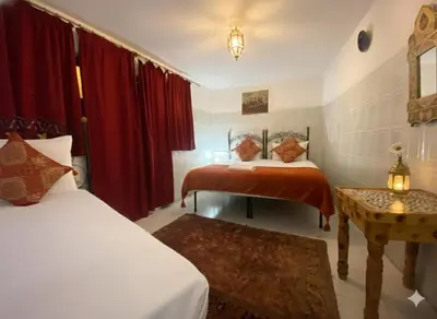 two beds in a room with red curtains at Fes Medina Vibes Hostel in Fès
