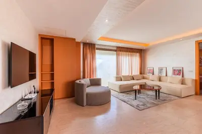 a living room with a couch and a tv at Riva Molière Parking Elegance in Oulad Akkou