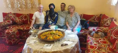 a group of people sitting on a couch with a table at Dar Chez Ali in Mhamid